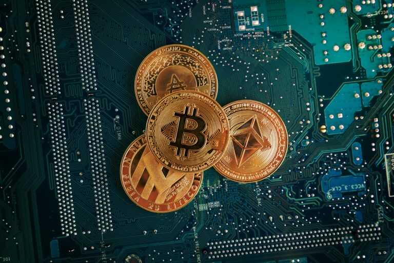 A closeup of Bitcoin, Ethereum, Litecoin and Cardano coins on the electronic circuit board.